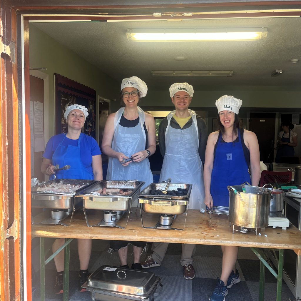 Volunteers at one of the kitchen serving stations. #DringyGroupCamp25